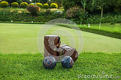 Lawn bowls leather bags and balls on the field side Stock Photo