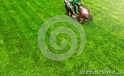 Lawn mower with gardener. Grass cutting. Aerial from drone. Stock Photo