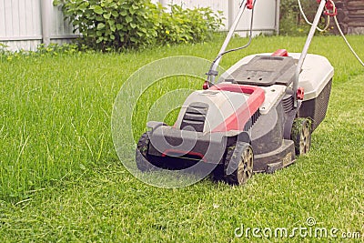 A lawn mower on a lush green. Details of landscaping and gardening Stock Photo