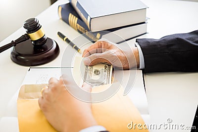 Lawyer being offered receiving money as bribe from client at desk in courtroom Stock Photo