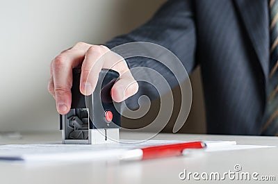 A lawyer or notary puts a seal on the document. A stamp in a man`s hand. Stock Photo