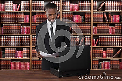 Lawyer With Papers And Briefcase At Desk Stock Photo