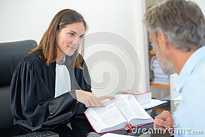 Lawyer showing text from book to client Stock Photo