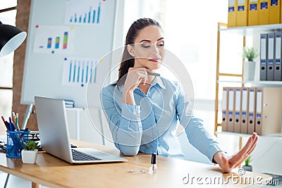 Layabout concept. Portrait of young cheerful cute woman in formal wear with pony tail, filing nails at her work station in office Stock Photo