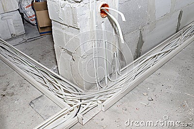 Layed installation of electric cables on the floor in a newly built house. Cables lying in plastic trays. Stock Photo