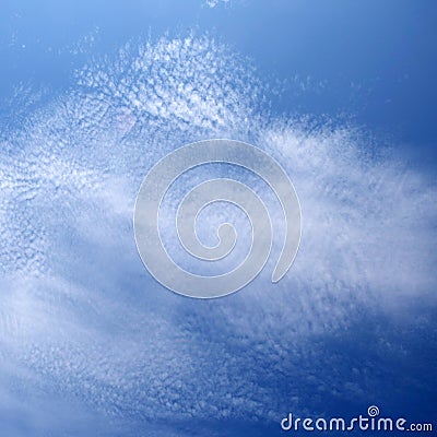 layer of broken stratus clouds under a deep blue sky Stock Photo