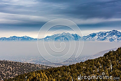 Thick Layer of Smog With Snow Capped Mountains In Background Stock Photo