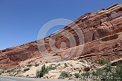 Layers of Entrada and Navajo sandstone lining the road in Arches National Park in Moab, Utah Stock Photo