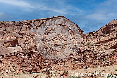 Layers of Entrada Sandstone behind the road leading into Arches National Park in Moab, Utah Stock Photo