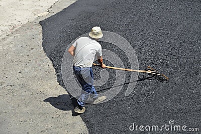 Laying asphalt. Road repairs. Hot asphalt on the road. Stock Photo