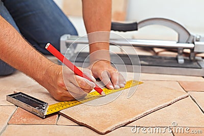 Laying ceramic floor tiles - man hands closeup Stock Photo