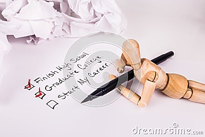 Laying daydreaming wooden jointed manikin doll holding a black ink pen education checklist Stock Photo