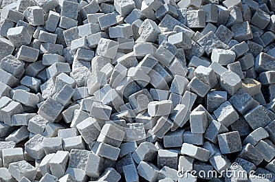 Laying granite and marble light, white gray, medium size cubes. tilers put cobblestones in sand or gravel. they have piles ready t Stock Photo