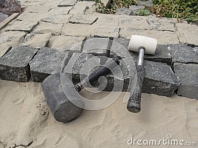 Laying granite paving stones - two rubber mallets close-up Stock Photo