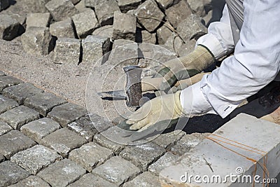 Laying natural granite stone cobbles in sand Stock Photo