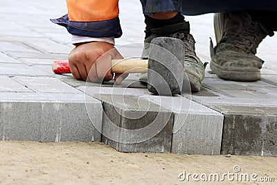 laying paving slabs on city square, repairing sidewalk. Stock Photo