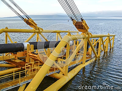 Laying of pipes with pipe-laying barge crane near the shore. Des Stock Photo
