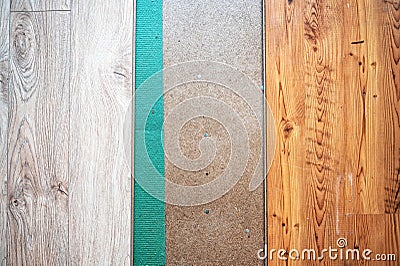 Laying a wooden laminate floor in room above a green sound-absorbing base, flooring in the house Stock Photo