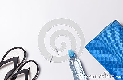 Layout with individual accessories for yoga, bodyflex, gymnastics. Yoga mat, water bottle, wireless headphones and slippers Stock Photo