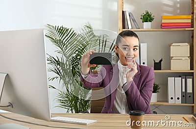 Lazy employee taking selfie at table in office Stock Photo