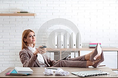 Lazy employee using tablet while resting at table Stock Photo