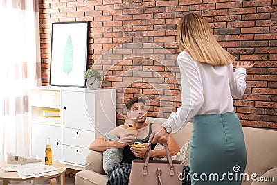 Lazy husband quarrelling with hardworking wife Stock Photo