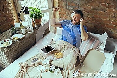 Lazy man living the whole life in his bed surrounded with messy Stock Photo