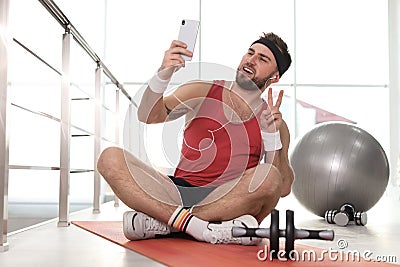 Lazy young man with sport equipment taking selfie Stock Photo