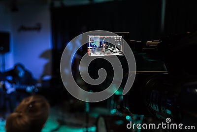 LCD display on the camcorder. Filming of the concert. Musicians playing the double bass, synthesizer, guitar and percussion Editorial Stock Photo