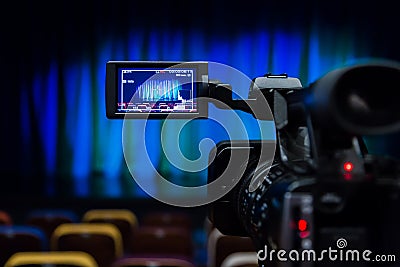 The LCD display on the camcorder. Shooting theatrical performances. The TV camera. Colorful chairs in the auditorium Stock Photo