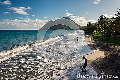 Le Diamant Beach in Martinique, with young man playing with a ba Editorial Stock Photo