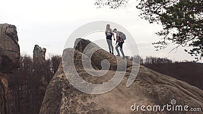 Le garçon et la fille sportifs avec un touriste balade escalader la montagne rocheuse, alors obtenant sur le dessus, tenant leurs clips vidéos Le garçon et la fille sportifs avec un touriste balade escalader la montagne rocheuse, alors obtenant sur le dessus, tenant leurs clips vidéos