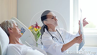 Le kvinnadoktorn som diskuterar x-strålen, avläs med hennes åldriga patient arkivfilmer Le kvinnadoktorn som diskuterar x-strålen, avläs med hennes åldriga patient arkivfilmer
