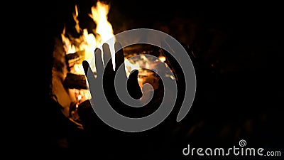 Le mani dell'uomo si riscaldano con il fuoco del campo. parti del corpo di un maschio adulto in natura. stock footage Le mani dell'uomo si riscaldano con il fuoco del campo. parti del corpo di un maschio adulto in natura. stock footage