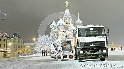 Le petit bouteur charge la 1ère neige humide aux camions sur la place rouge Le petit bouteur charge la 1ère neige humide aux camions sur la place rouge