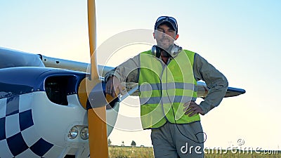 Le pilote masculin se tient près d'un avion privé léger Une personne se tient près d'un petit avion, regardant et souriant l'appa banque de vidéos Le pilote masculin se tient près d'un avion privé léger Une personne se tient près d'un petit avion, regardant et souriant l'appa banque de vidéos