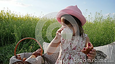 Le portrait mignon de petite fille boit du lait, mangeant le petit pain, croissant au coucher du soleil, la nature de pique-nique banque de vidéos Le portrait mignon de petite fille boit du lait, mangeant le petit pain, croissant au coucher du soleil, la nature de pique-nique banque de vidéos