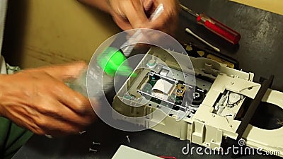 Le technicien humidifie le tampon de coton de l'alcool pour nettoyer la tête de laser de DVD banque de vidéos Le technicien humidifie le tampon de coton de l'alcool pour nettoyer la tête de laser de DVD banque de vidéos