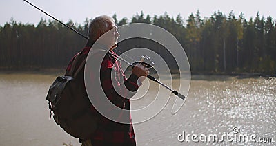 Le voyageur avec le sac à dos et la canne à pêche se tient sur la haute côte de la rivière et admire la nature banque de vidéos Le voyageur avec le sac à dos et la canne à pêche se tient sur la haute côte de la rivière et admire la nature banque de vidéos