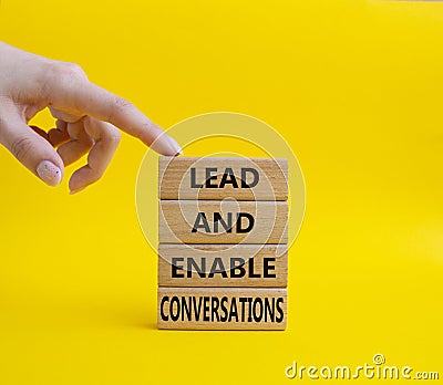 Lead and enable conversations symbol. Concept words Lead and enable conversations on wooden blocks. Beautiful yellow background. Stock Photo