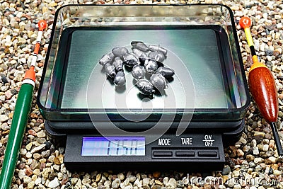 Lead weights for fishing floats on a pocket scale Stock Photo