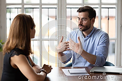Leader in eyeglasses explaining project details to new female employee. Stock Photo