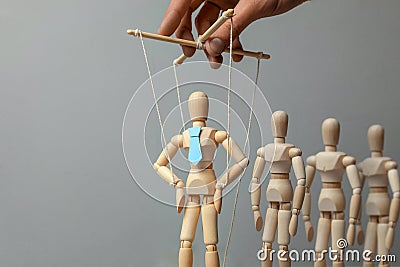 Leader puppet activist and workers. Concept of how to manage leader in team. Doll in tie on the ropes controlled by hand Stock Photo