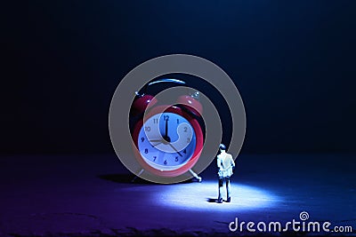 Leadership concept, miniature man looking at clock, deadline and challenge idea Stock Photo