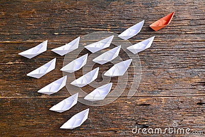 Leadership concept with orange paper ship leading white ship on Stock Photo