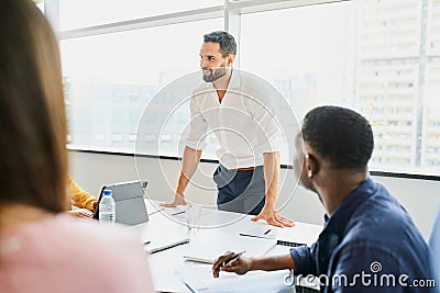 Smiling businessman lead a meeting with group of employees workmates in office Stock Photo