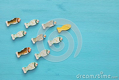 Leadership concept with swimming fish on wooden background. One leader leads others. Stock Photo