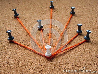 Leadership or delegation concept. The pins are connected by a thread to the main. Stock Photo