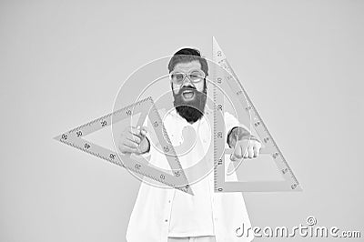 Leading engineer of the project. Smart engineer holding triangles on yellow background. Teaching engineer smiling with Stock Photo