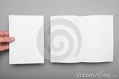 Leaflet A5 flyer mockup in man hand on grey background Stock Photo